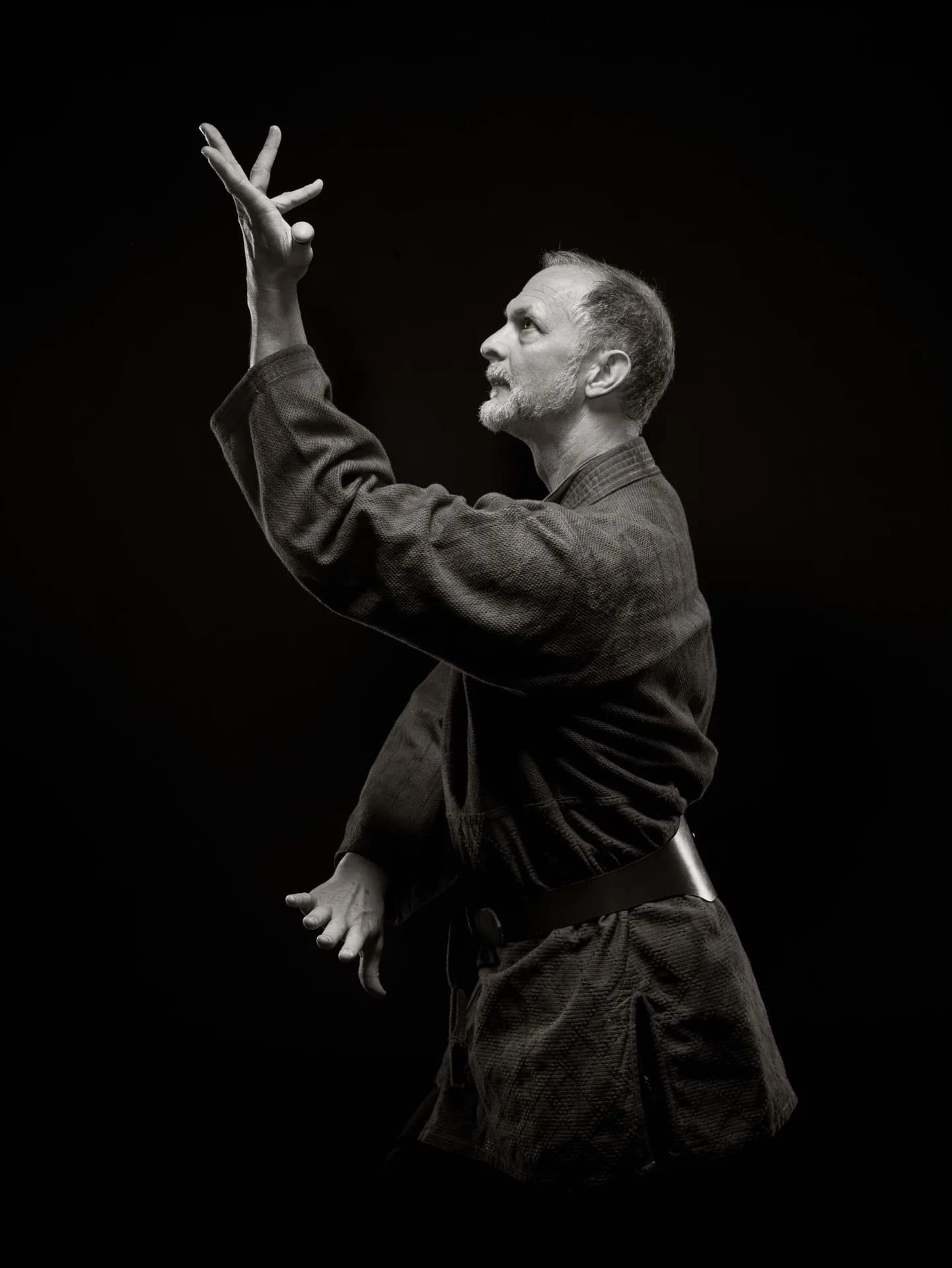 Allen Pittman in a poised gesture against a dark background